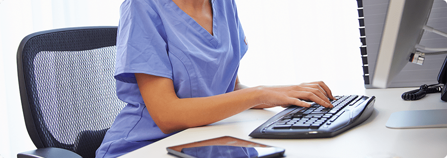 Female nurse in an office typing on a keyboard